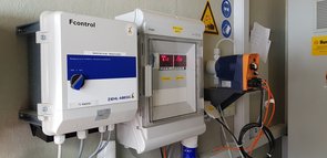 Blick in den Technikraum mit Dosierpumpe für Säure (orange), pH- und Leitwert Anzeige des Prozesswassers und Steuerung der Ventilatoren (vorne)